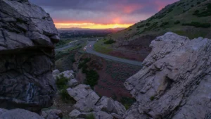 Rugged mountain rocks in foreground with winding mountain road in background