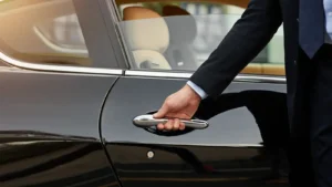 Man grabbing a silver door handle on a black vehicle providing Vail transportation services